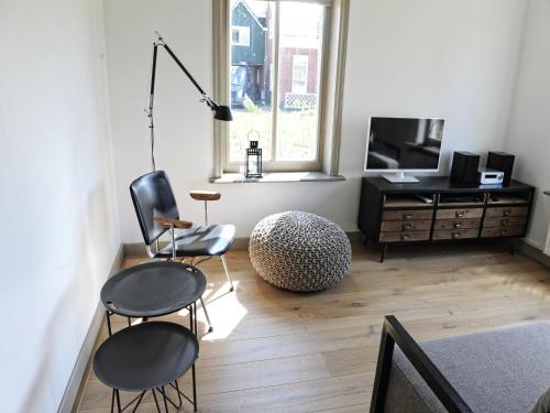 a living room with two chairs and a television at Holiday Home Zoutkamp near Lauwersmeer in Zoutkamp