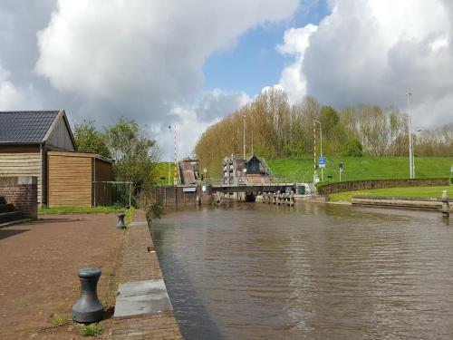 a body of water with a bridge in the background at Holiday Home Zoutkamp near Lauwersmeer in Zoutkamp