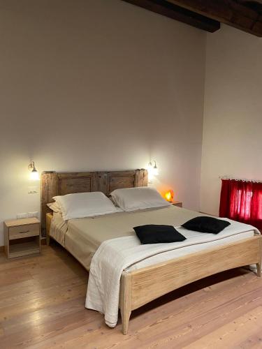 a bedroom with a large bed with white sheets at Albaspina BioAgriturismo in Monticello Conte Otto