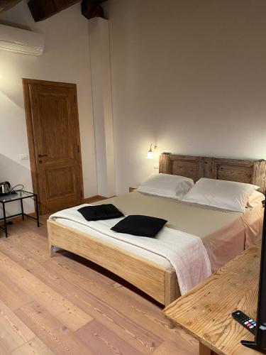a bedroom with a large bed with two pillows on it at Albaspina BioAgriturismo in Monticello Conte Otto