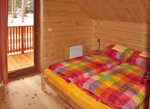 um quarto com uma cama num chalé de madeira em Chata Iľanovka em Demanovska Dolina