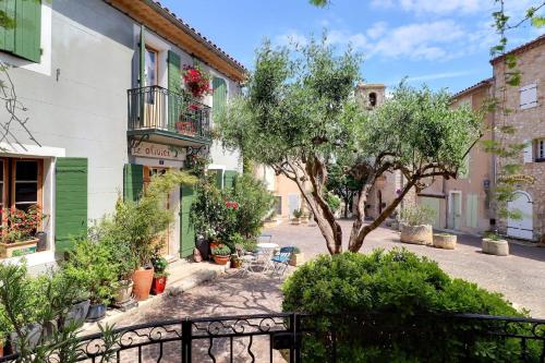 a street in a town with a tree and buildings at L’oustaou de Ventabren Village Square in Ventabren