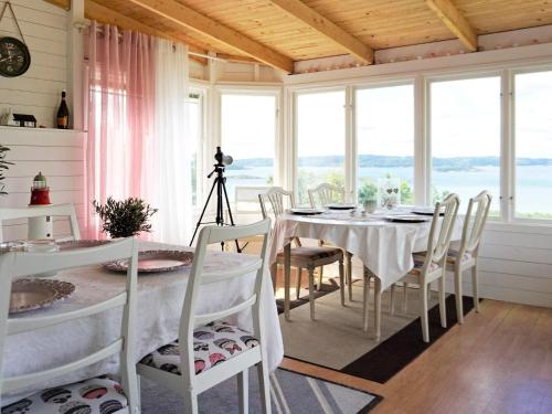 a dining room with a table and chairs and windows at 5 person holiday home in Uddevalla in Uddevalla