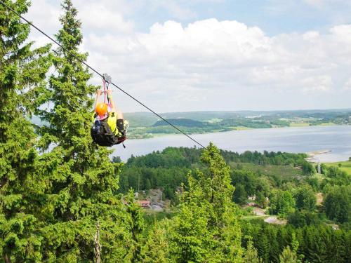 a person on a zip line hanging from a tree at 5 person holiday home in Uddevalla in Uddevalla