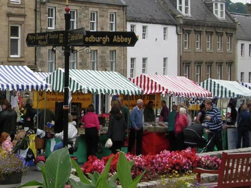 a group of people walking around a market with tents at Cottage in Jedburgh with Stunning Views in Jedburgh