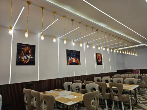 ein Esszimmer mit Tischen, Stühlen und Lichtern in der Unterkunft Clarissa Resort, Mukteshwar in Mukteswar