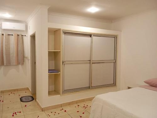 a bedroom with a window with red flowers on the floor at Legacy accommodation in Vila-de-Santiago-Maior