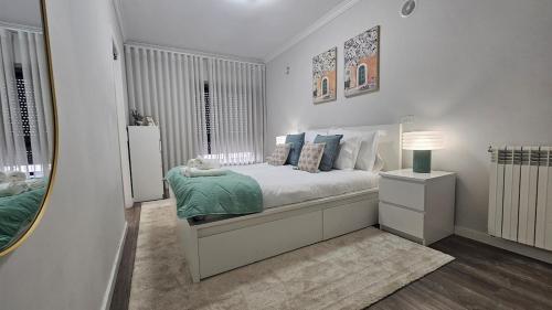 a white bedroom with a bed and a mirror at Wicalia ShortStays in Mem Martins