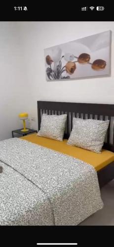 a bed with two pillows and avertisement for at Family Friendly 3BR with Free Parking - in Rishon Letzion in Rishon LeẔiyyon