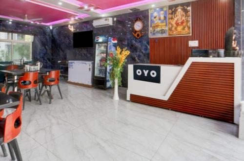 a restaurant with a tv and tables and chairs at Hotel The Sangat Prime 
