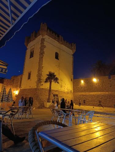 a building with people sitting at tables in front of it at مقهى المدينة احبك in Asilah