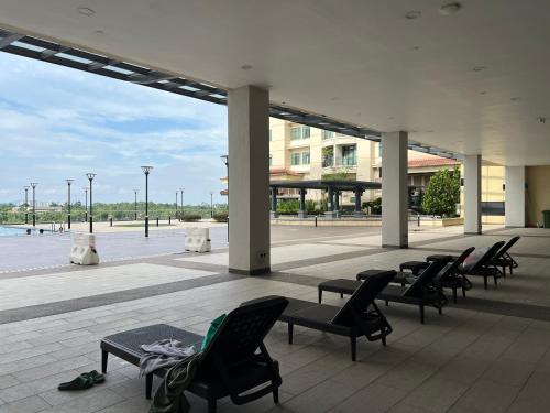 a group of chairs and tables on a patio at LoFF Suite River View 2 Bedroom at Kuching Riverine Resort in Kuching