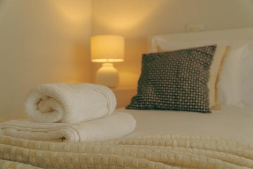 a pile of towels sitting on top of a bed at Wicalia ShortStays in Mem Martins