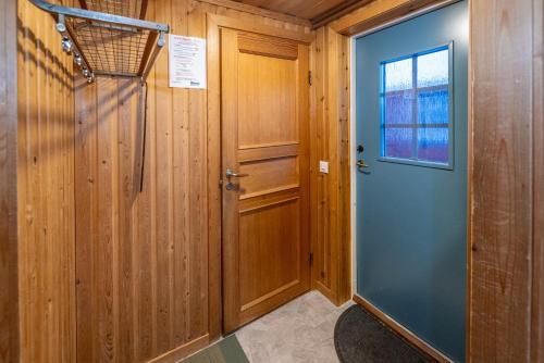 a hallway with a blue door and a window at Bruksvallslidens förmedling in Bruksvallarna