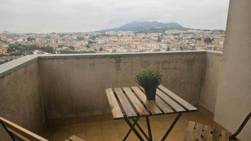 a wooden table with a potted plant on a balcony at Wicalia ShortStays in Mem Martins