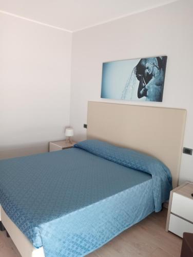 a bedroom with a bed with a blue blanket at Residence Hotel Azzurro in LʼAquila