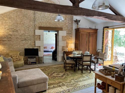 a living room with a table and a dining room at Cottage in Saint-Jean with Terrace in Frontenay-sur-Dive