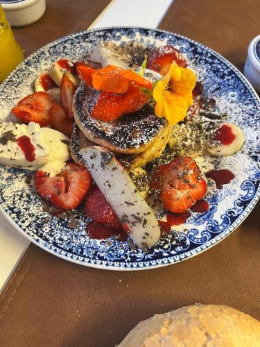 a plate of food with pancakes and strawberries on a table at Hof van In & Wellness in Hasselt