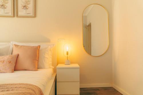 a bedroom with a bed and a mirror on the wall at Wicalia ShortStays in Mem Martins