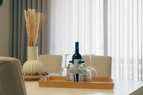 a wooden tray with bottles and glasses on a table at Wicalia ShortStays in Mem Martins