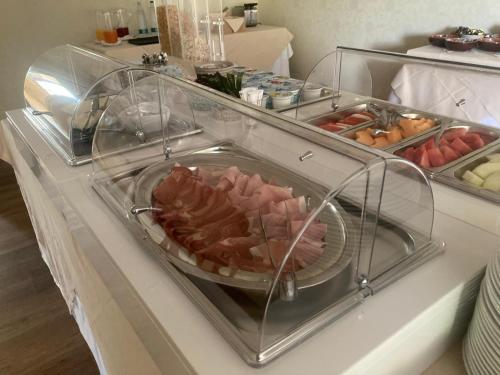a buffet with a plate of meat in a display case at Hotel Villa Conte Riccardi in Rocca D'Arazzo
