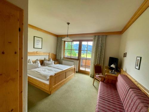 a bedroom with a large bed and a window at Pension Möslehnerhof in Ramsau am Dachstein