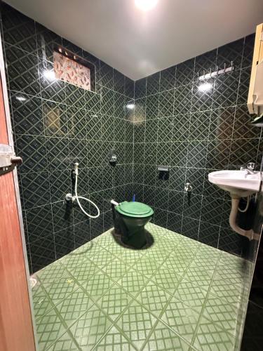 a bathroom with a green toilet and a sink at Serene Palolem guest house in Palolem