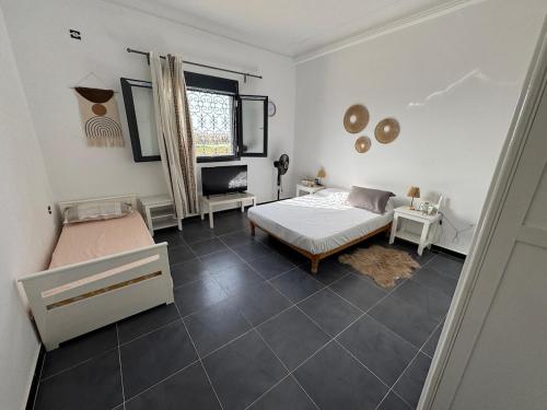 a bedroom with a bed and a chair and a window at Large villa & pool in Mosta in La Celle-sous-Gouzon