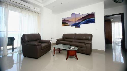 a living room with a couch and a table at Ocean Breeze Condo in Negombo