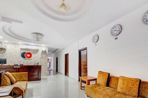- un salon avec un canapé et des horloges murales dans l'établissement LRC Hotel & Banquet Zirakpur, à Mohali