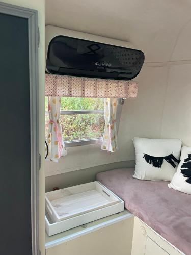 a small room with a window and a suitcase at Salève Glamping in Archamps