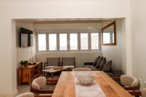 een woonkamer met een houten tafel en stoelen bij Queens View 33 in Margate