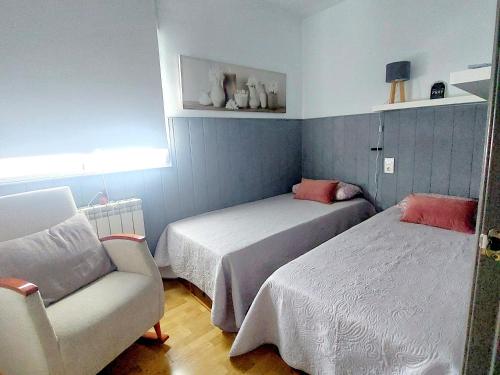 a bedroom with two beds and a couch and a chair at Amplio apartamento con terraza con vistas "Victoria Stay" in Alcalá la Real