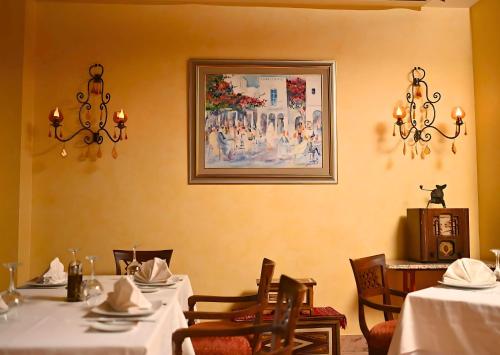 a dining room with two tables and a picture on the wall at Borj Dhiafa in Sfax
