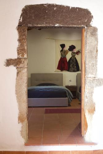 a bedroom with two dresses hanging on the wall at Rebeccu Arte e Ospitalità - Ostello in Rebeccu