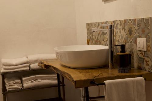 a bathroom with a bowl sink on a wooden table at Rebeccu Arte e Ospitalità - Ostello in Rebeccu