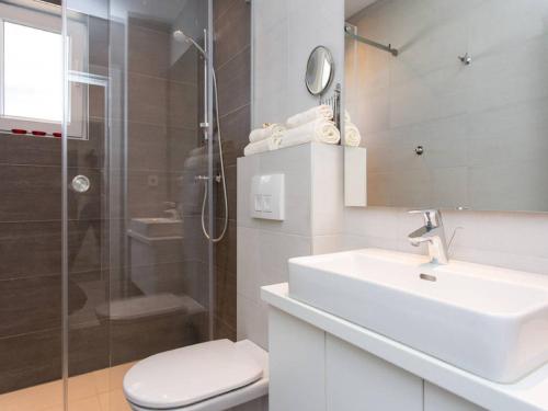 a bathroom with a sink and a shower and a toilet at Guest house Mazuth in Rab