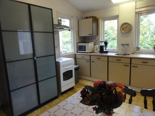 a kitchen with a refrigerator and a table in it at Holiday Home Koewacht near Seaside in Nieuwemolen