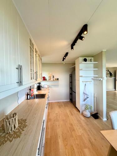 a kitchen with white cabinets and a wooden floor at Top location - Amazing views in Tromsø
