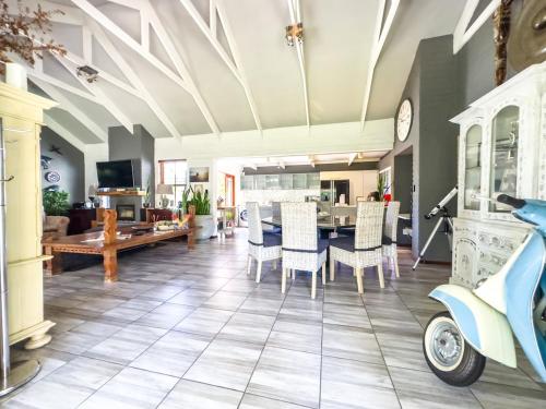 a living room with a table and a scooter at 3 on Pine, Luxury Home[WiFi,DSTV,Parking incl] in George
