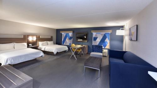 a hotel room with two beds and a couch at Holiday Inn Express Hotel & Suites Waterloo - St. Jacobs Area by IHG in Waterloo