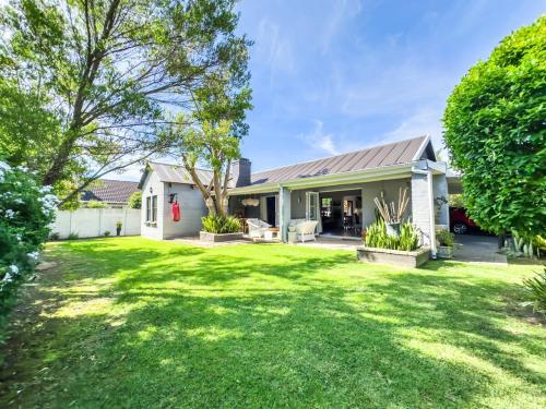 a house with a green yard at 3 on Pine, Luxury Home[WiFi,DSTV,Parking incl] in George