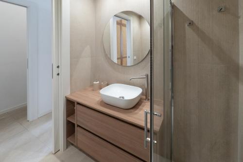 a bathroom with a sink and a mirror at Cálida apartments in Cefalù