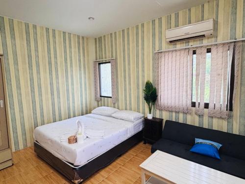 a bedroom with a bed and a couch at Jura 88 Guesthouse in Hua Hin