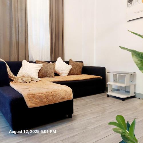 a living room with a couch and a table at Charming 2BR Apartment with Balcony and Mountain View - Logan's Transient Apartment 2 in Baguio