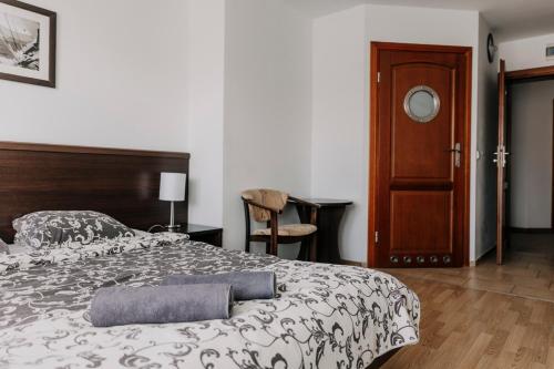 a bedroom with a large bed and a wooden door at Willa Latarnik - doskonała lokalizacja, blisko atrakcji, 20min do plaży in Łeba