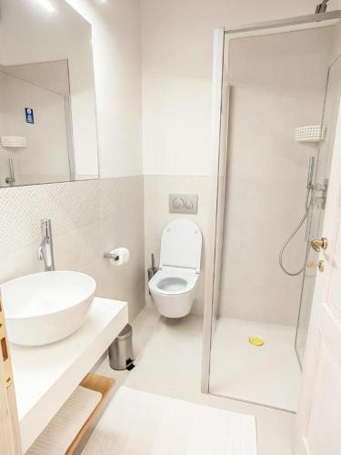 a white bathroom with a toilet and a sink at Home Dren in Prepotto