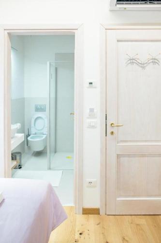 a bedroom with a bathroom with a toilet and a door at Home Dren in Prepotto