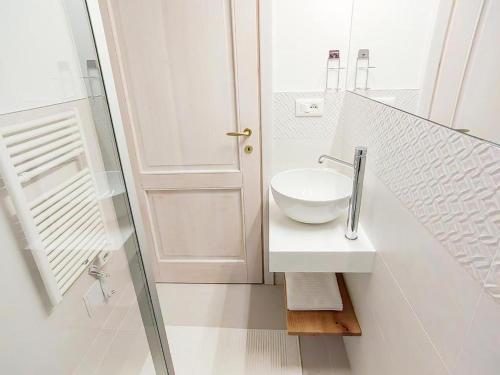 a white bathroom with a sink and a mirror at Home Dren in Prepotto