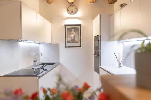 a kitchen with a sink and a clock on the wall at Home Dren in Prepotto